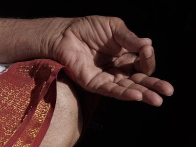 Close-up of hands in a peaceful mudra position.