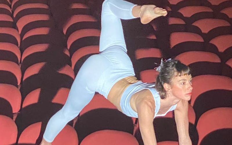 Person performing a wide-stance yoga pose with focused expression.