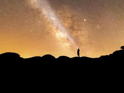 Silhouette of a person meditating against a window.